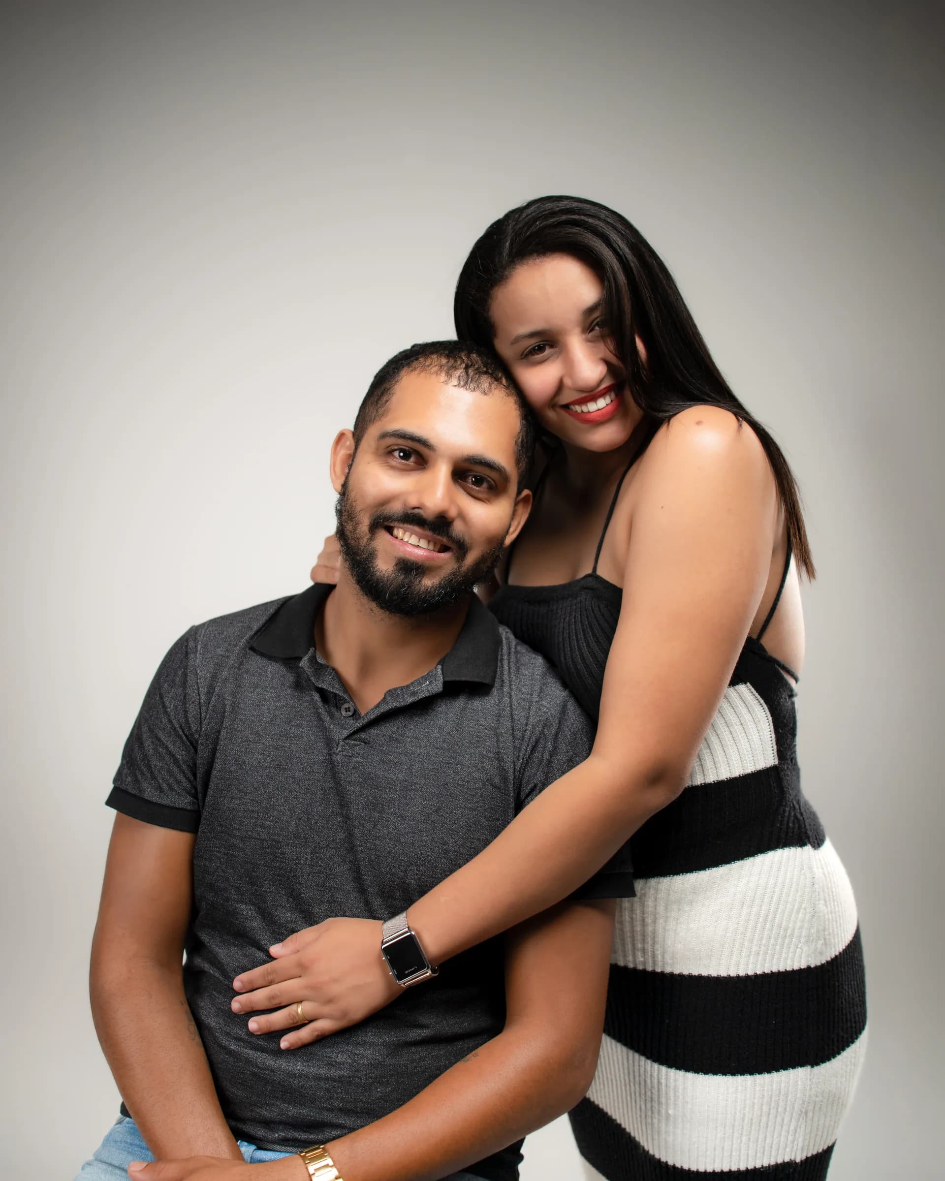 Casal abraçado com os rostos próximos, sorrindo
