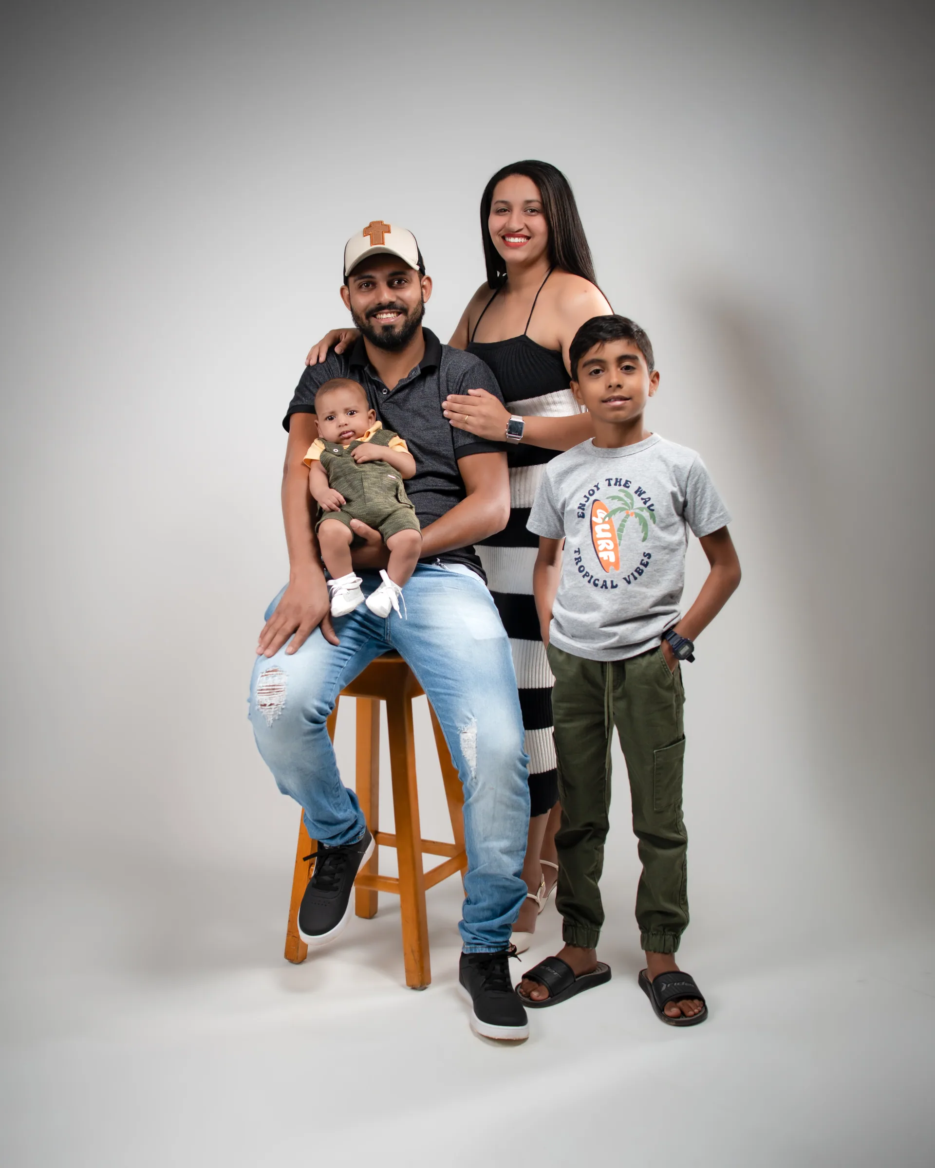 Família reunida: pai sentado no banco com o bebê, mãe e filho ao lado